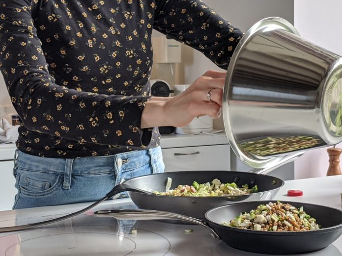 oman-in-blue-denim-jeans-holding-stainless-steel-c oman in blue denim jeans holding stainless steel cooking pot