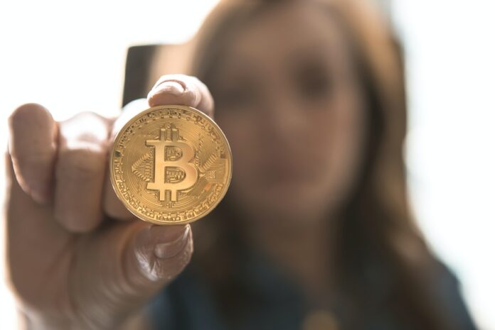Photo by André François McKenzie woman holding Bitcoin