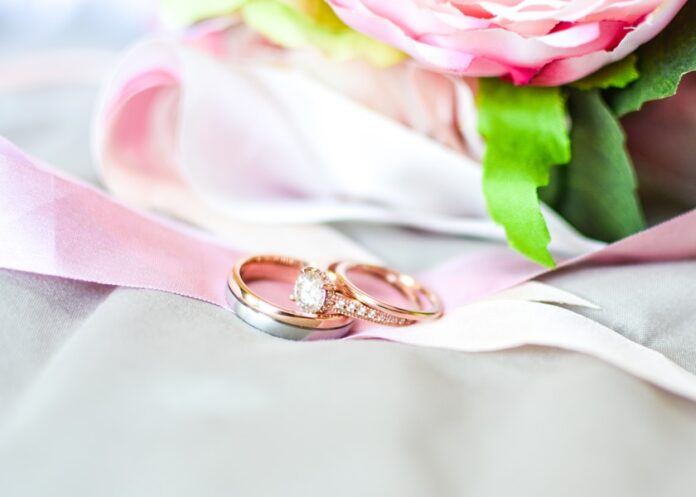 Photo by SYNG silver-and-gold-colored rings near pink flower