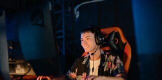 Photo of a Man Playing on a Computer while Smiling