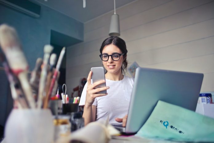 Photo by bruce mars woman in white shirt using smartphone