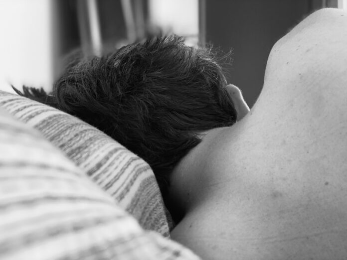 Photo by Madalyn Cox grayscale photo of woman lying on bed