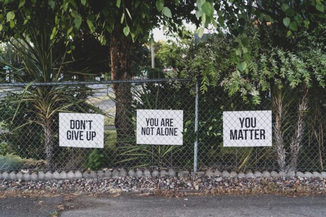Photo by Dan Meyers don't give up. You are not alone, you matter signage on metal fence