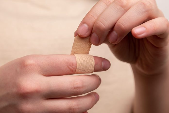 Photo by Diana Polekhina person with band aid on middle finger