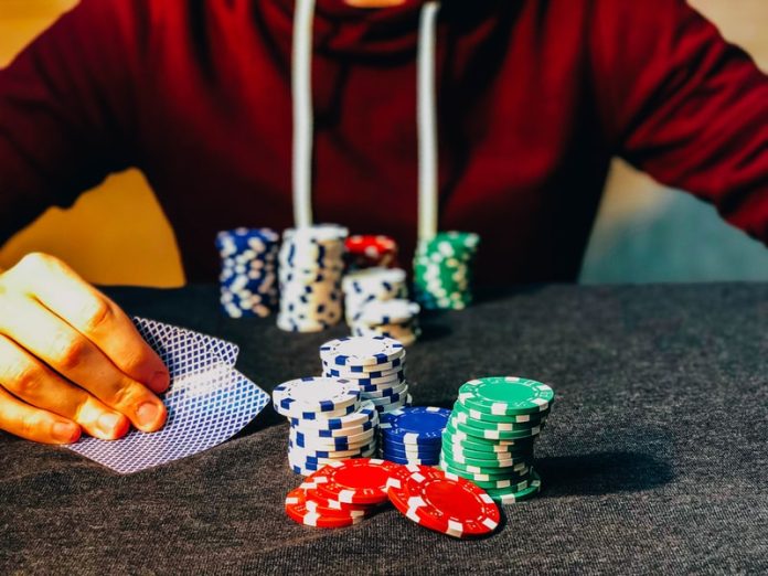 Photo by Chris Liverani person sitting near poker chips