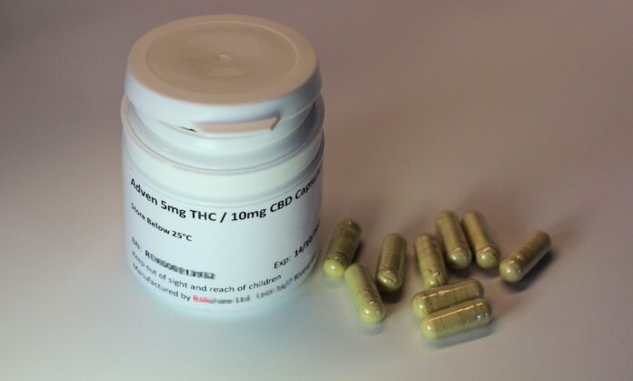 white plastic bottle with brown tablets