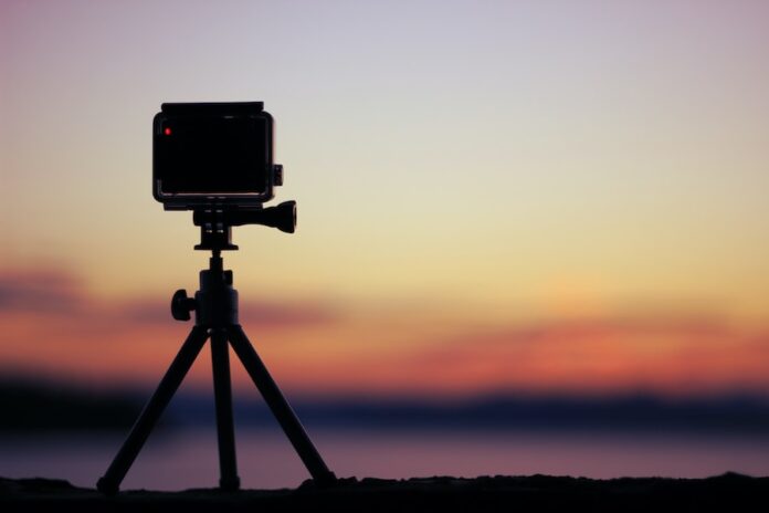 Photo by frame harirak selective focus photo of black action camera on black tripod