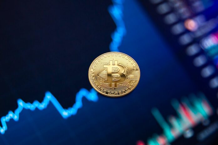 Photo by Ivan Babydov Gold bitcoin coin on background of growth chart