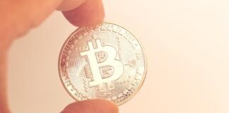 Fingers Holding Round Silver Coin