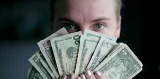 person holding fan of U.S. dollars banknote