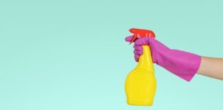 person holding yellow plastic spray bottle