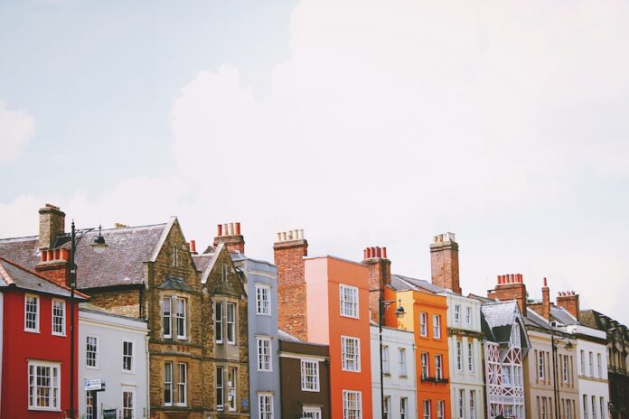 Photo by Toa Heftiba assorted-color concrete houses under white clouds during daytime