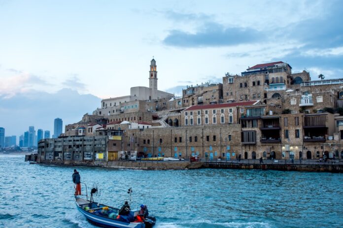 Photo by Faruk Kaymak three person riding on blue motorboat near brown buildings during daytime