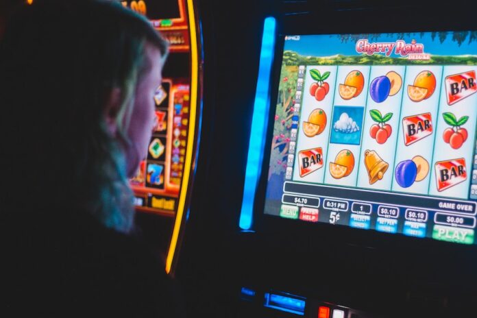 Photo by Erik Mclean man playing slot machine game