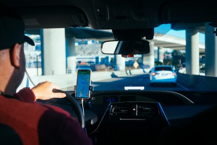 Photo by Paul Hanaoka person holding iphone 6 inside car
