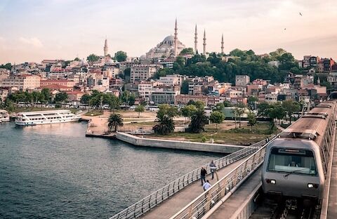 Photo by Fatih gray and black train traveling on top of bridge during daytime