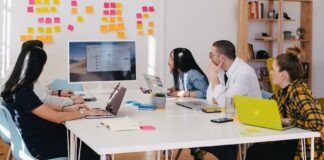 five person by table watching turned on white iMac