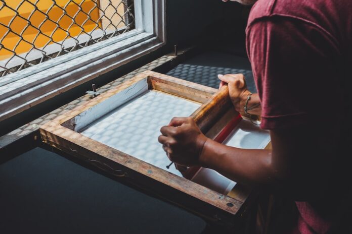 Photo by emarts emarts man holding printing screen near white window