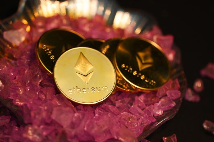Photo by Traxer two gold coin sitting on top of a pile of pink crystals