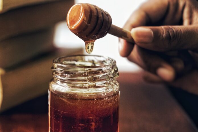 Photo by Arwin Neil Baichoo honey jar with honey comb