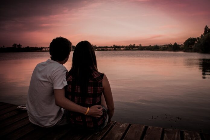 Photo by Jose Chomali man and woman sitting on dock
