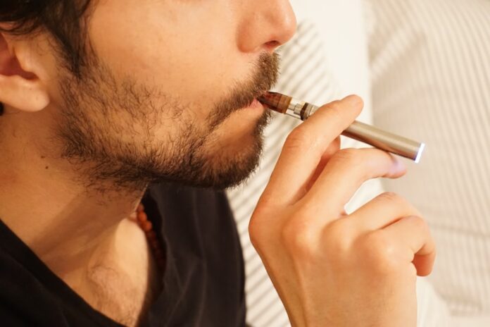 Photo by Elsa Olofsson man in black shirt smoking cigarette