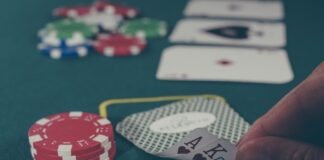 Top 7 Myths Quickwin Players Must Know Before Gambling person holding black ace and king spades playing cards on poker table
