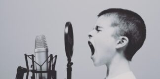 boy singing on microphone with pop filter