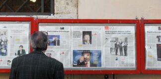 man reading newspaper in bulletin board