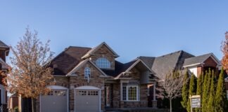 brown and white wooden house near green trees under blue sky during daytime