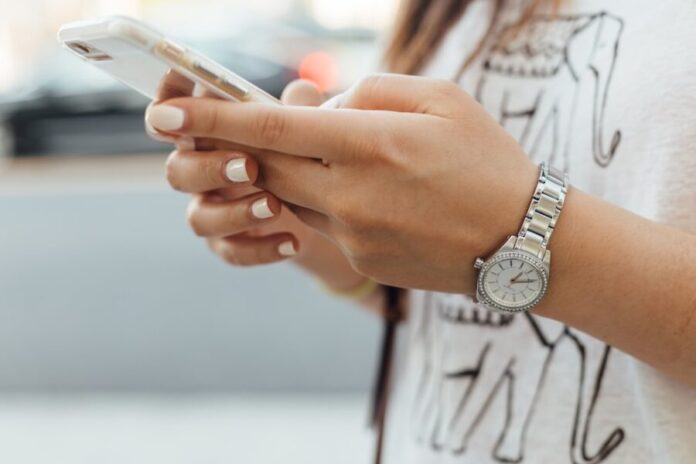 woman-holding-iphone-during-daytime woman holding iPhone during daytime