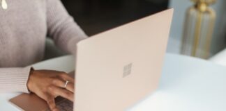 person in gray long sleeved shirt using Surface laptop
