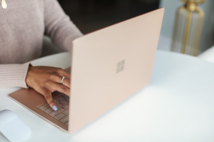 Photo by Surface person in gray long sleeved shirt using Surface laptop
