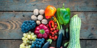 a variety of fruits and vegetables on a wooden surface