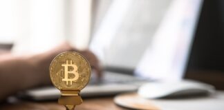 gold-colored bitcoin on brown table