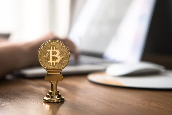 Photo by André François McKenzie gold-colored bitcoin on brown table