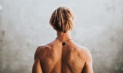 Photo by Nathan Dumlao half naked man facing wall