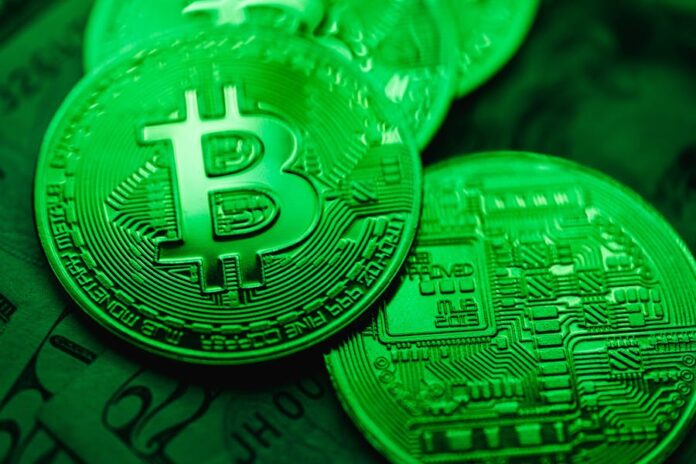 Photo by Karolina Grabowska Closeup of Bit Coins in a Green Light