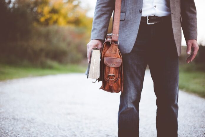 Photo by Ben White man holding book on road during daytime