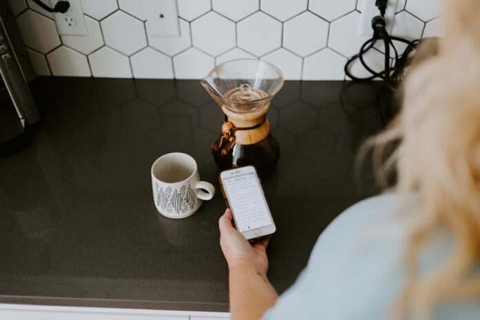 Photo by Samantha Borges person holding white box near clear glass mug