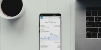 a cell phone sitting on top of a desk next to a laptop