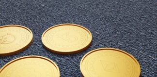 four gold tokens sitting on a blue carpet