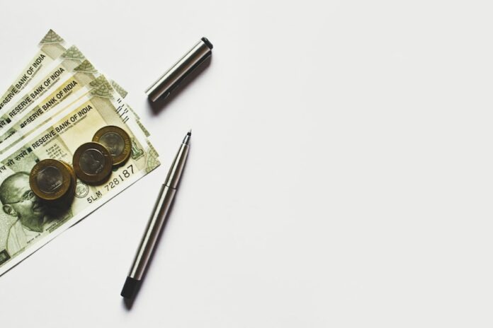 Photo by rupixen gray pen beside coins on Indian rupee banknotes