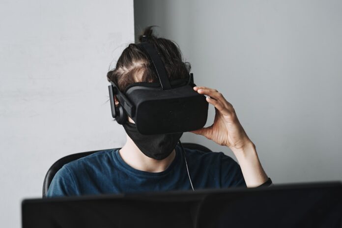 Photo by Maxim Tolchinskiy man in blue crew neck shirt wearing black vr goggles