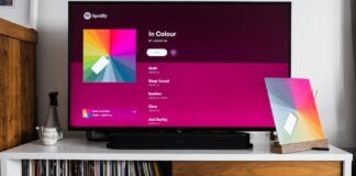 a flat screen tv sitting on top of a white shelf
