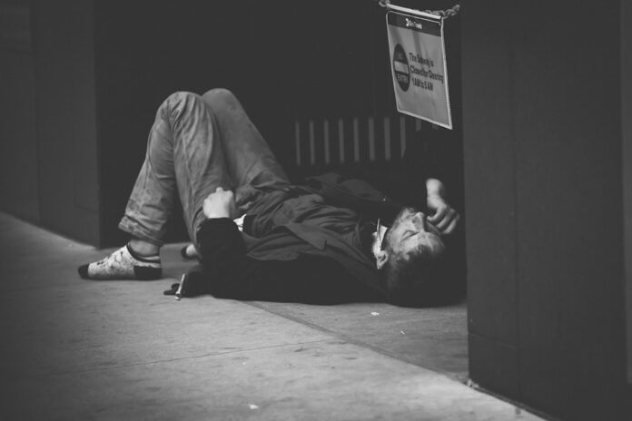 Photo by Jon Tyson man lying on floor in grayscale photography