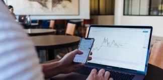 person using smartphone and MacBook Pro