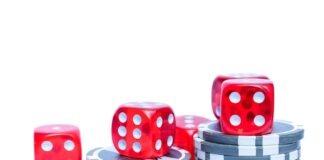 Vibrant red dice stacked with poker chips, ideal for gambling themes.