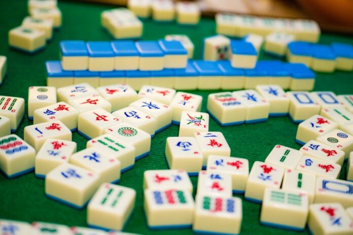 Photo by Jimmy Chan Close-up of colorful mahjong tiles on green felt, showcasing a variety of designs and symbols.