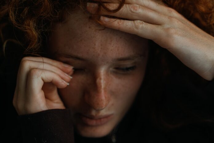 Photo by Tom Caillarec a close up of a person holding their head